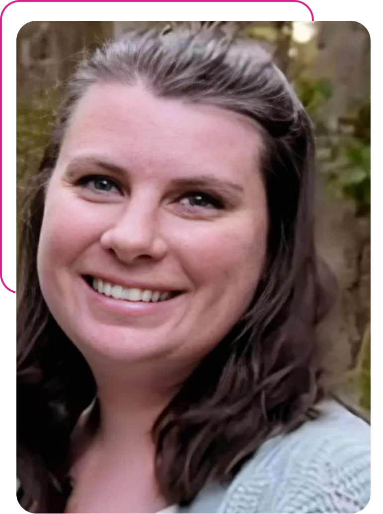 A woman smiling for the camera with her hair in front of a wall.